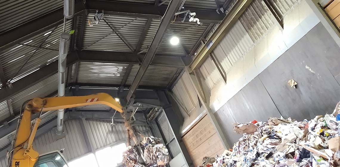 View inside a waste management facility hall with installed IR camera and FireDos fire monitor for early fire detection