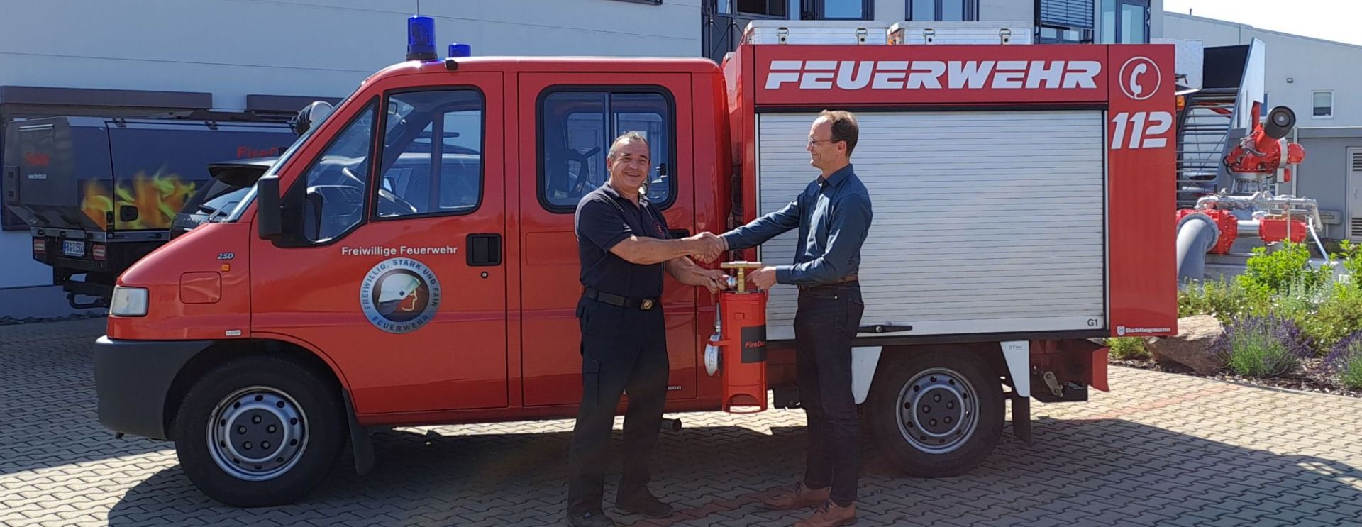 Frank Preiss presents Dieter Nicolai with a fire bucket pump